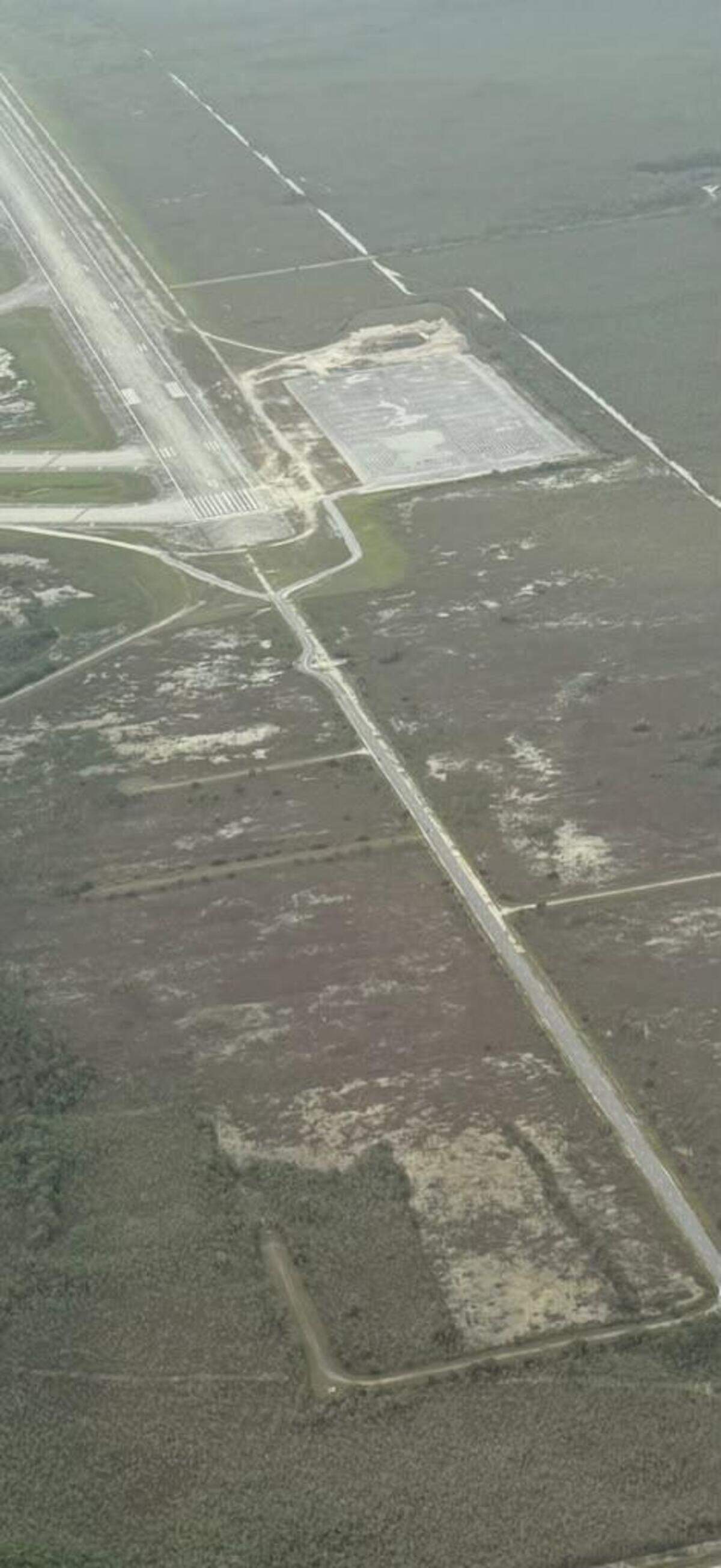 An aerial photo shows the asphalt parking lot that was added to the Dade-Collier Training and Transitional Airport as part of its transformation into Alligator Alcatraz, a key part of the environmental lawsuit.